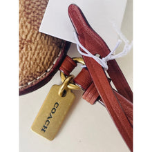 Load image into Gallery viewer, Brown leather product with a gold tag featuring the Coach logo on a white background
