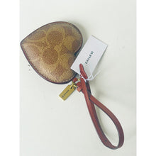 Load image into Gallery viewer, Coach leather product with brown textured surface and red strap on a white background