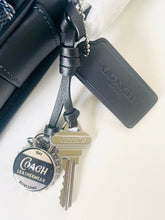 Load image into Gallery viewer, Coach branded keychain with keys and leather strap on a white surface