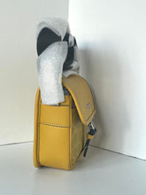 Load image into Gallery viewer, Yellow leather bag with a black and white patterned sock on a white background