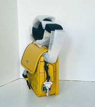 Load image into Gallery viewer, Yellow backpack with a checkered scarf draped over it on a white background