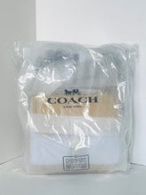 Load image into Gallery viewer, White shirt with Coach branding in a clear plastic bag on a white background