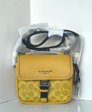 Load image into Gallery viewer, Yellow Coach handbag with black strap on a white background