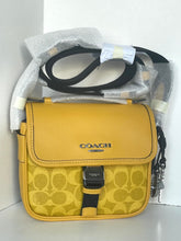 Load image into Gallery viewer, Yellow Coach handbag with black strap on a white background