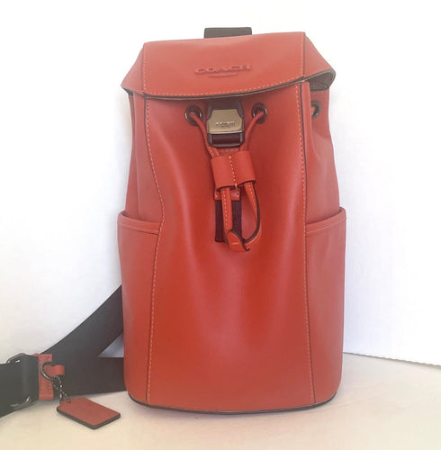 Red backpack with a strap and tag on a white background