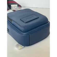 Load image into Gallery viewer, Blue leather bag with Coach logo on a light background