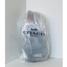 Load image into Gallery viewer, Coach backpack in clear plastic wrap on a white background