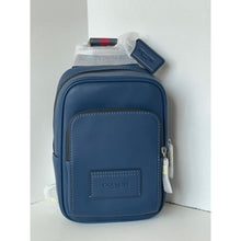 Load image into Gallery viewer, Blue Coach pouch with a white shirt and red pen inside on a light gray background