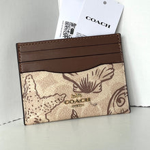 Load image into Gallery viewer, Coach cardholder with brown leather strip and logo on a light gray background