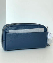 Load image into Gallery viewer, A navy blue pebbled leather pouch bag with a silver zipper and a horizontal silver metallic accent stripe on the front, shown against a plain white background.