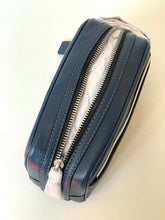 Load image into Gallery viewer, A dark navy blue pebbled leather zippered pouch or cosmetic case, shown from an angled top-down view on a light beige background. The pouch features a silver-toned metal zipper and a small dark blue tab near the top edge.