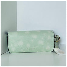 Load image into Gallery viewer, Light green leather handbag with a strap on a light gray surface.