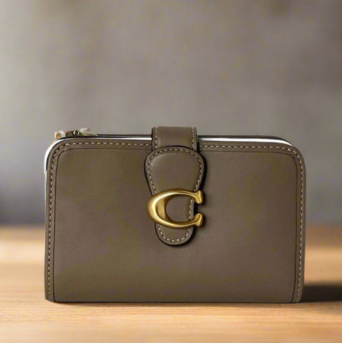 Brown wallet with gold clasp on a white surface