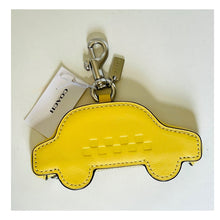 Load image into Gallery viewer, Yellow car-shaped keychain with Coach tag on a white background
