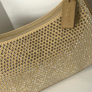 Gold clutch bag with rhinestone embellishments and a visible brand tag.