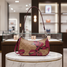 Load image into Gallery viewer, Handbag with floral pattern and Coach logo on a light gray background