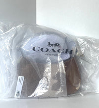 Load image into Gallery viewer, A Coach New York handbag inside a clear plastic protective bag, showing a light gray leather top with the black Coach logo and a brown leather strap.