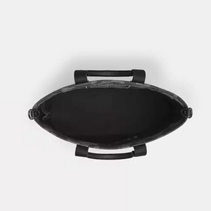 Black leather handbag with handles on a white background