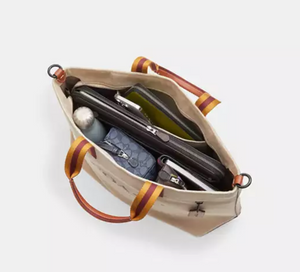 Open beige handbag with compartments on a white background