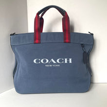 Load image into Gallery viewer, Blue Coach bag with red handles on a white background