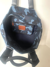Load image into Gallery viewer, Camouflage-patterned backpack with a brown leather patch on a light background