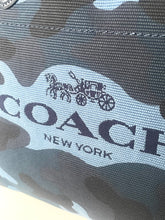 Load image into Gallery viewer, Close-up of a Coach New York logo on a product, with a camouflage pattern.