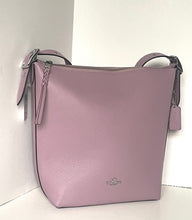 Load image into Gallery viewer, A light purple pebbled leather shoulder bag with a top zipper, braided strap detail, and silver-tone hardware, photographed in a corner against a white wall.