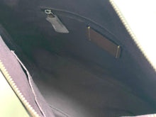 Load image into Gallery viewer, Close-up view of the interior of a dark purple or black bag, showing a zippered compartment with a small leather patch and zipper pull.