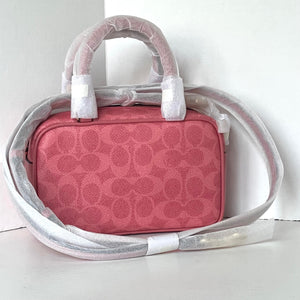 Pink handbag with a white strap on a light gray background
