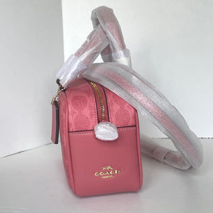 Pink Coach handbag with a white strap on a white background
