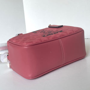 Pink textured bag with a strap on a white background