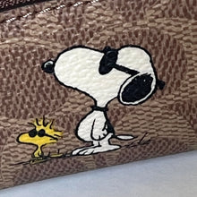 Load image into Gallery viewer, Close-up of a brown textured surface with an embroidered design of a dog and a bird. snoopy woodstock