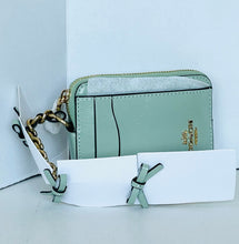 Load image into Gallery viewer, A Coach crossbody wallet in light mint green leather with a gold-tone chain strap, displayed with its white paper tags against a white background.