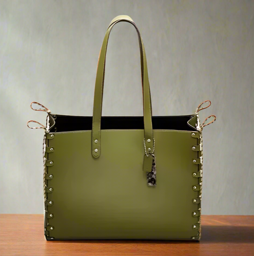 Green handbag with studded details on a white background