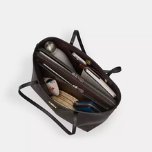 Load image into Gallery viewer, Black handbag with items inside on a white background