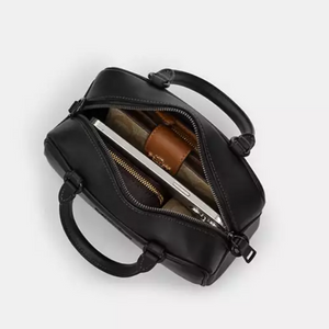 Black leather handbag with a zipper on a white background