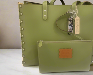Green leather bag with studded details on a white surface