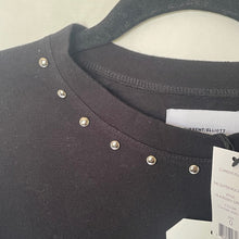 Load image into Gallery viewer, Black top with decorative studs and a brand tag on a white background