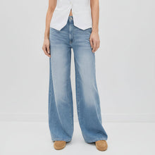 Load image into Gallery viewer, Person wearing light blue wide-leg jeans on a plain background