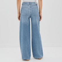 Load image into Gallery viewer, Light blue wide-leg jeans worn by a person on a white background