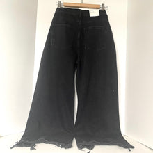 Load image into Gallery viewer, Black wide-leg jeans on a hanger against a white background
