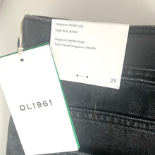 Load image into Gallery viewer, Black denim jeans with a DL1961 tag on a white background