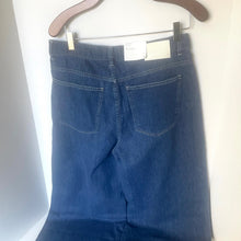 Load image into Gallery viewer, Blue jeans on a hanger against a white background