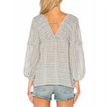 Load image into Gallery viewer, Woman wearing a striped blouse with a deep neckline and denim shorts on a white background