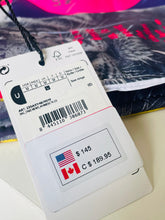 Load image into Gallery viewer, A close-up of a white garment size tag attached to a garment, showing size information, barcode, and a price label with US $145 and Canadian C $189.95.