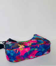 Load image into Gallery viewer, A zippered pouch with a vibrant, multicolored abstract floral pattern in pink, blue, green, and yellow, featuring a black strap and zipper pull on a plain white background.