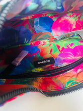 Load image into Gallery viewer, Close-up of the colorful interior lining of a zippered bag, featuring a bright floral print in pink, blue, green, orange, and red. A small black fabric label with the brand name 'Desigual' is visible near the center.