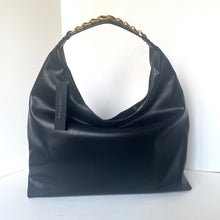 Load image into Gallery viewer, Black handbag with gold chain handle on a white background