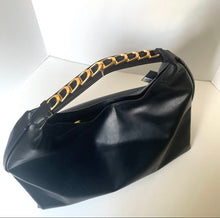 Load image into Gallery viewer, Black handbag with gold chain handle on a white background