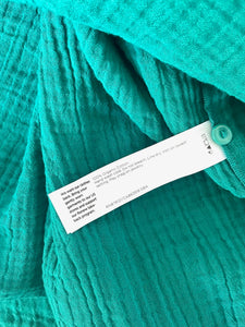 Teal sweater with a label on a white background